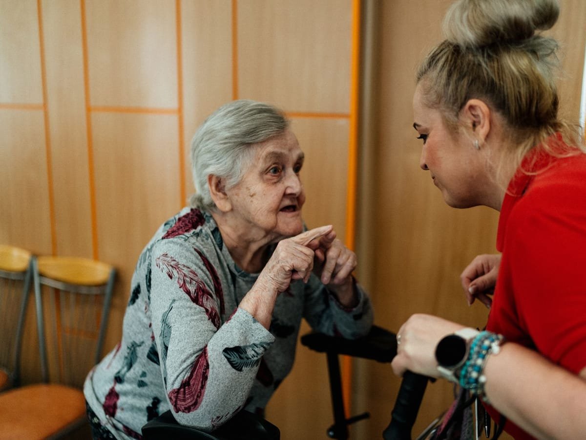 A care worker in conversation with an elderly woman at home