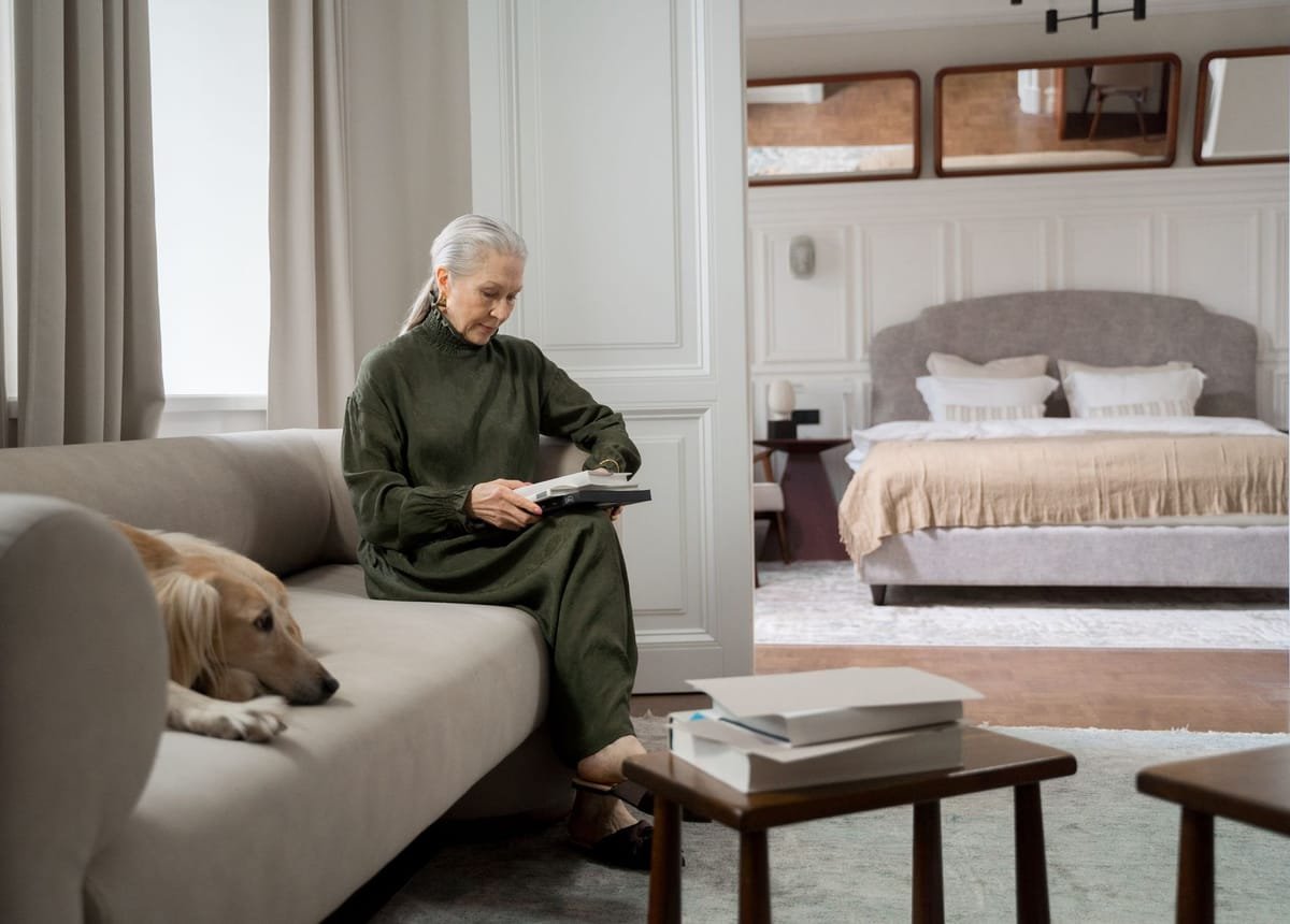 A senior woman reading a book in her own living room